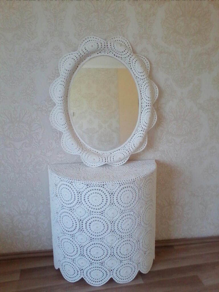 Setul unic de consolă semiovală cu oglindă de machiaj este croșetat manual din bumbac 100% și aplicate perle Swarovski, oferind un aspect elegant și proaspăt. Produsul este rigidizat cu rășini epoxidice, garantând durabilitate și stabilitate în timp. Este perfect pentru adolescentele care apreciază atingerile realizate manual și caută o piesă de mobilier practică și elegantă pentru zona lor de machiaj.